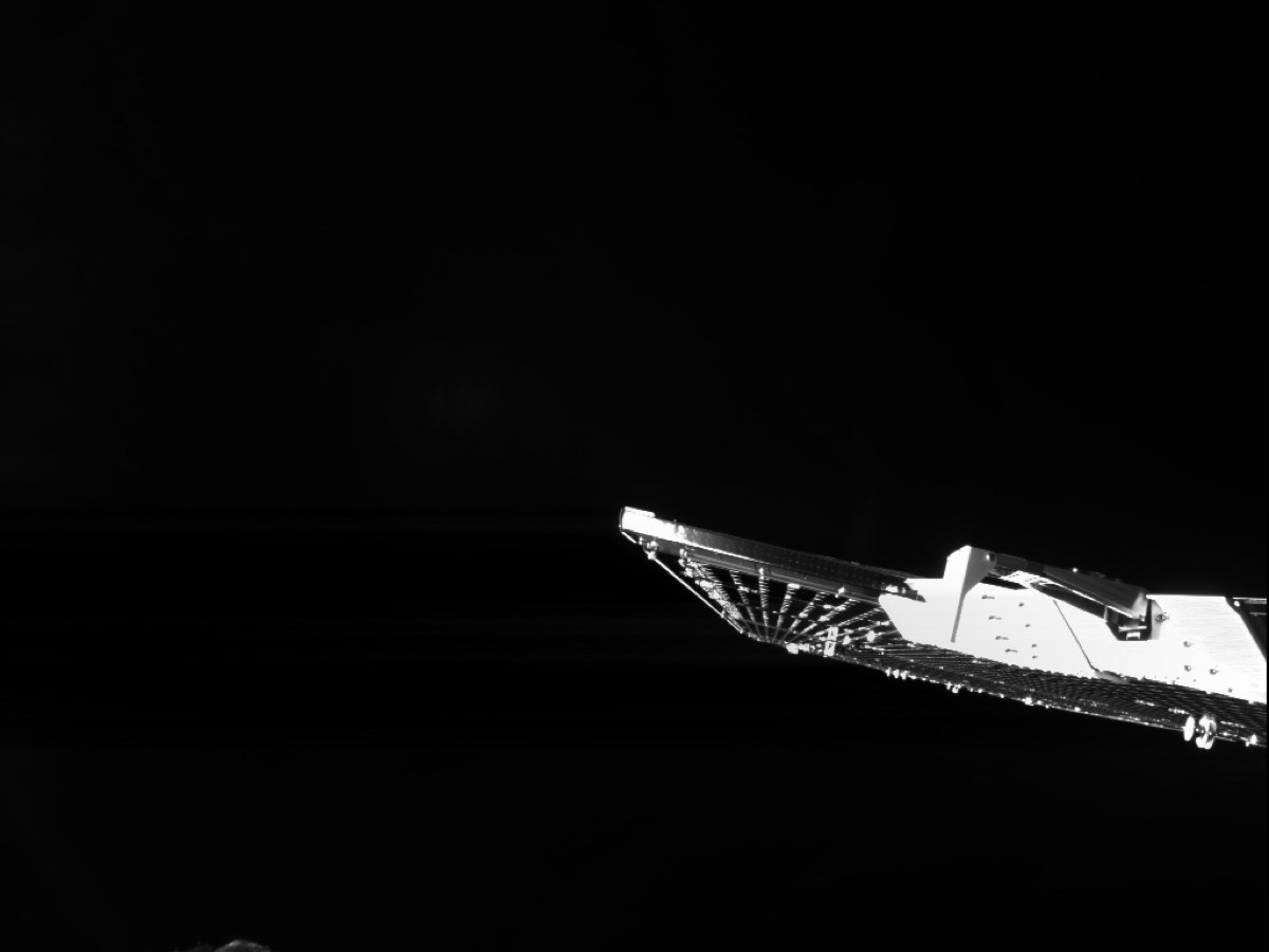 Vue rapprochée du module de transfert d’une sonde spatiale, aile solaire éclairée sur fond noir