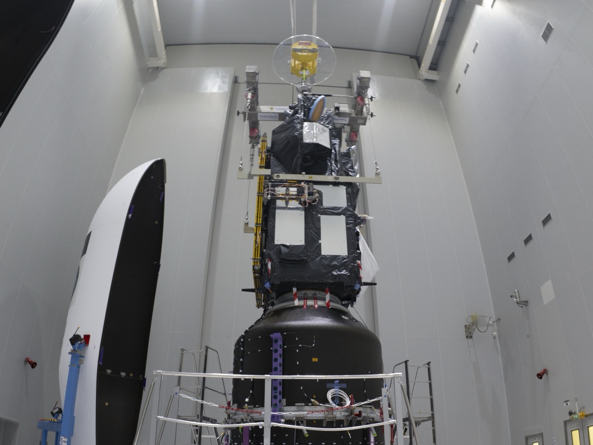 Sentinel-3C emballé de couvertures thermiques noires, fixé au sommet de l'adaptateur Vespa qui contient FLEX, dans le hall d'encapsulation du Centre spatial guyanais