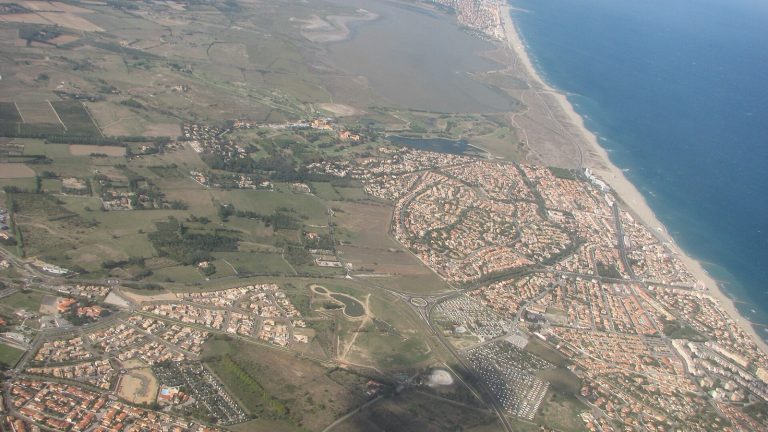 Vue aérienne du littoral du Roussillon : Saint-Cyprien au premier plan, l'étang de Canet-Saint-Nazaire, le cordon de plage et Canet-en-Roussillon au loin
