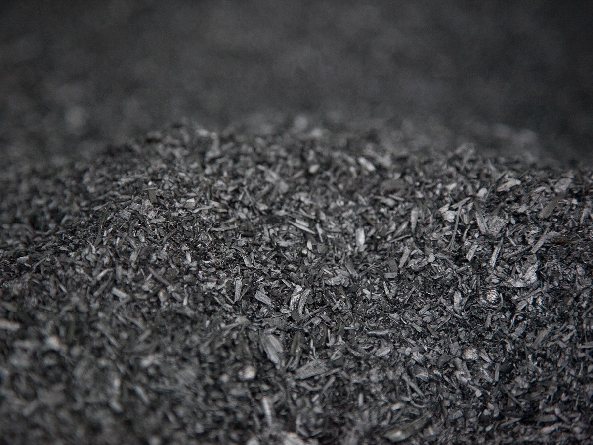 Gros plan sur un tas de biochar, fines particules de charbon végétal noires et brillantes