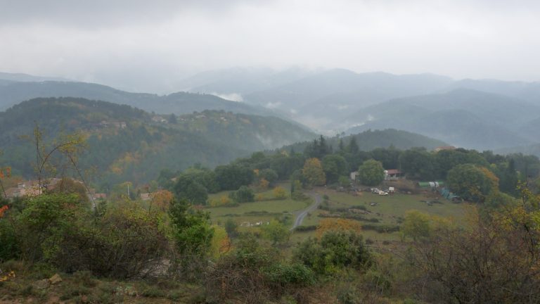 Vallées boisées des Cévennes sous la pluie, nuages bas accrochés aux crêtes et feuillages d'automne