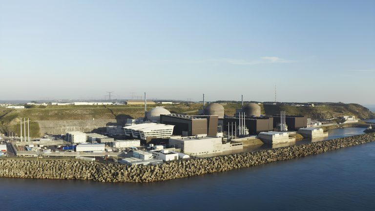 Centrale nucléaire vue depuis la mer, le réacteur EPR au premier plan et deux réacteurs plus anciens en arrière-plan