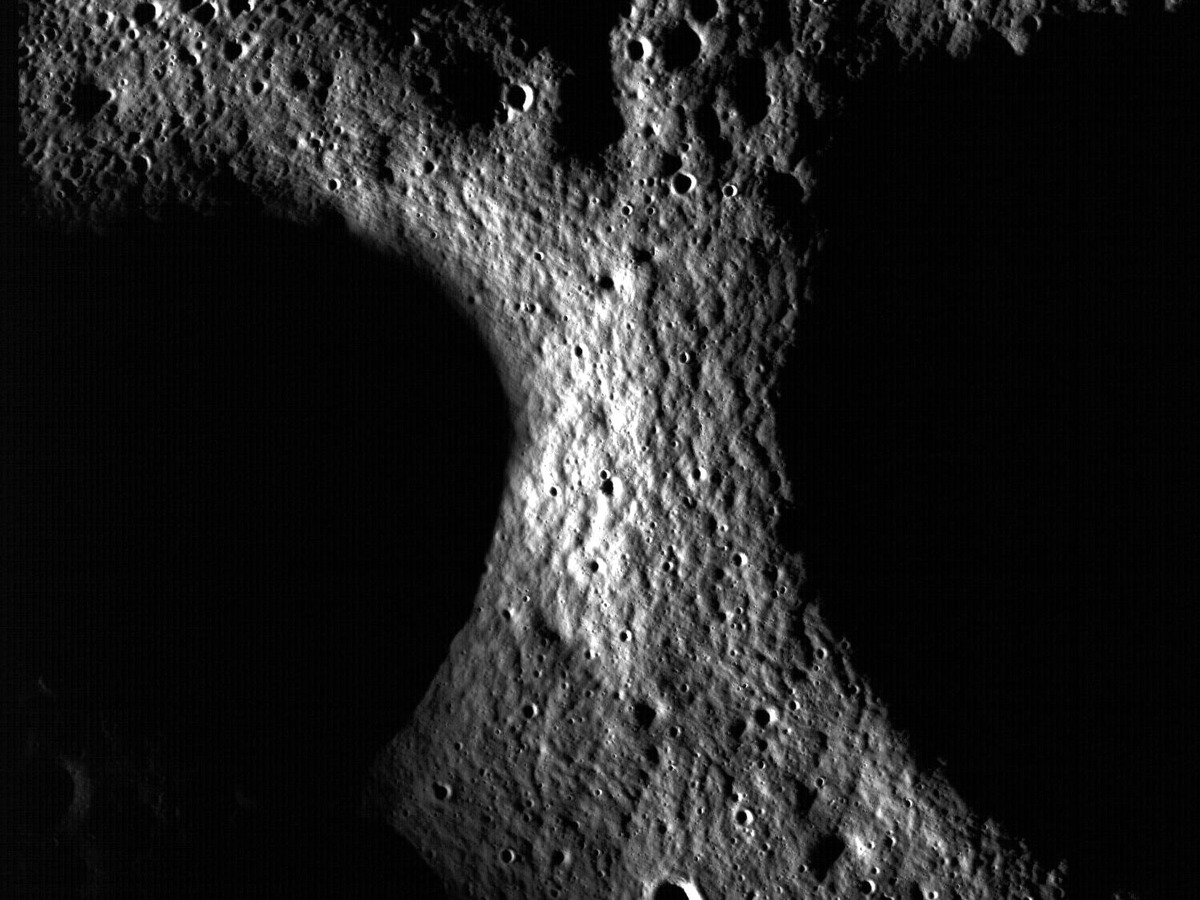Bords de cratères lunaires éclairés de biais, entourés de zones entièrement noires