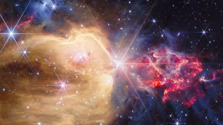 Nuage de gaz doré et rouge parsemé d'étoiles brillantes, vu en infrarouge