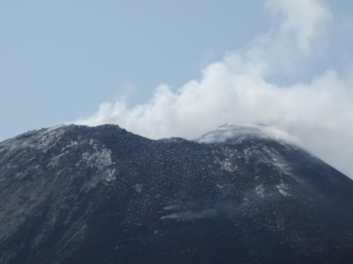 Sommet de l'Anak Krakatau couvert de cendres noires, avec un panache blanc qui s'échappe du cratère