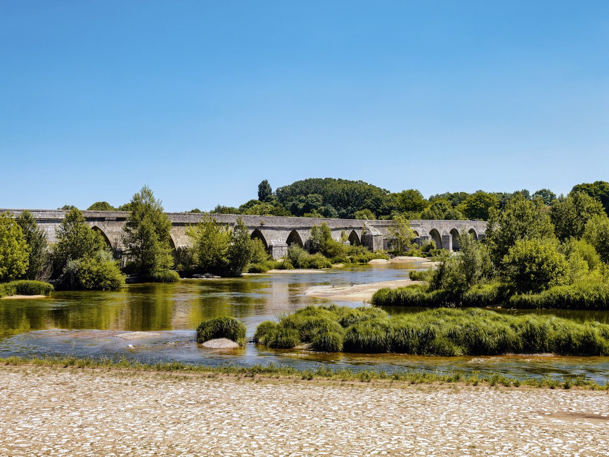 Le pont médiéval de Beaugency sur la Loire, avec de larges bancs de graviers découverts au premier plan
