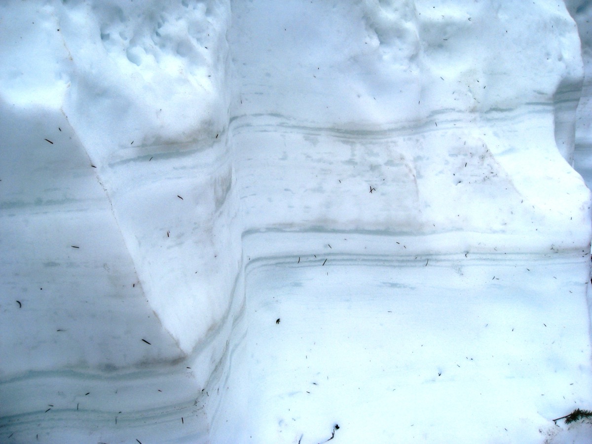 Couches de neige superposées visibles dans une paroi de neige découpée