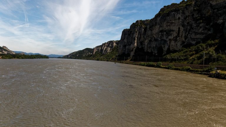 Le Rhone coulant au pied de falaises calcaires boisees, dans une vallee resserree