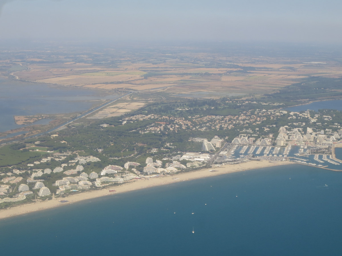 Vue aérienne d'une station balnéaire du littoral méditerranéen avec sa plage, son port de plaisance et ses immeubles en pyramide