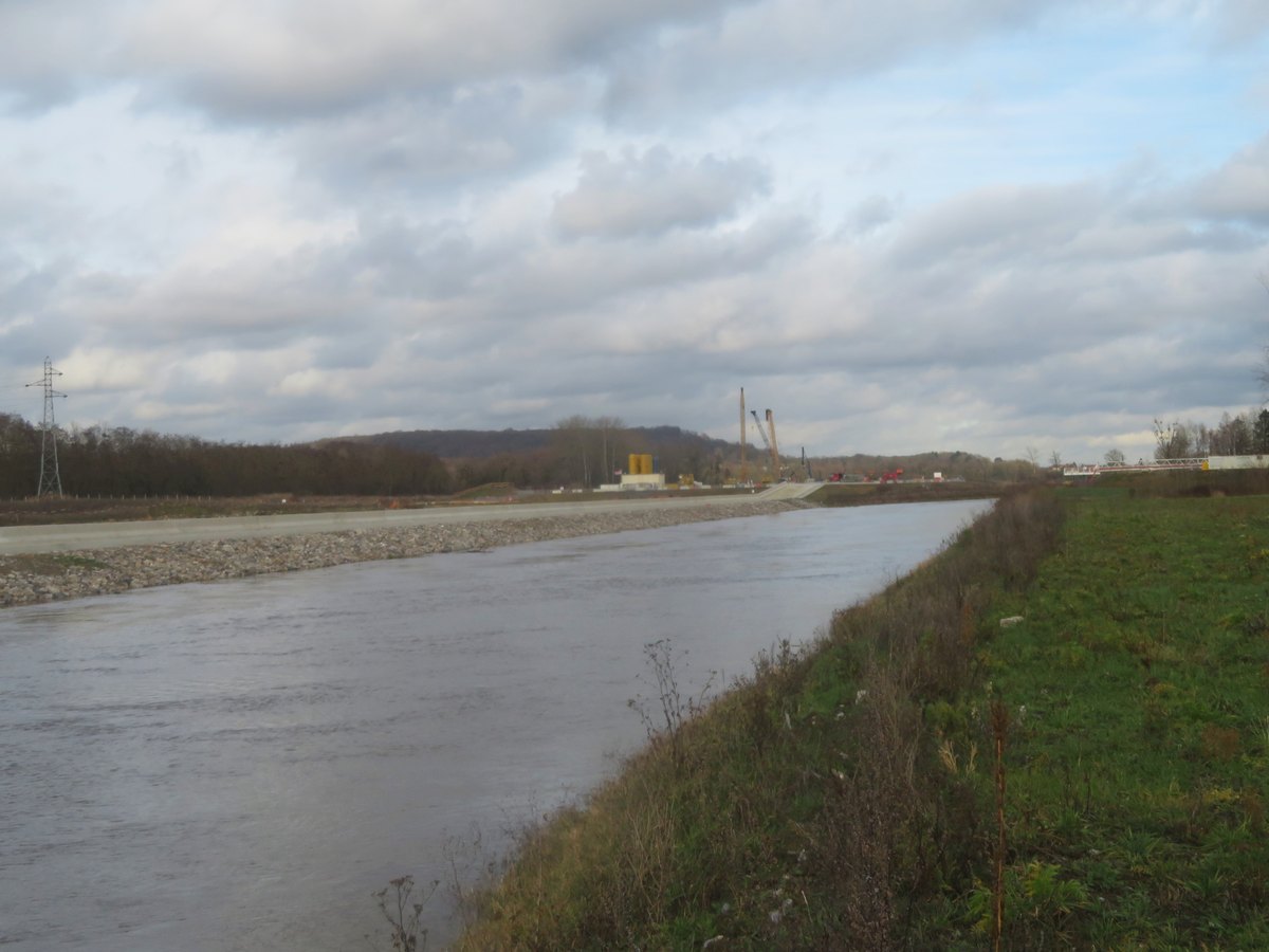 Travaux préparatoires de l'écluse de Montmacq, au bord de l'eau, avec des grues à l'horizon