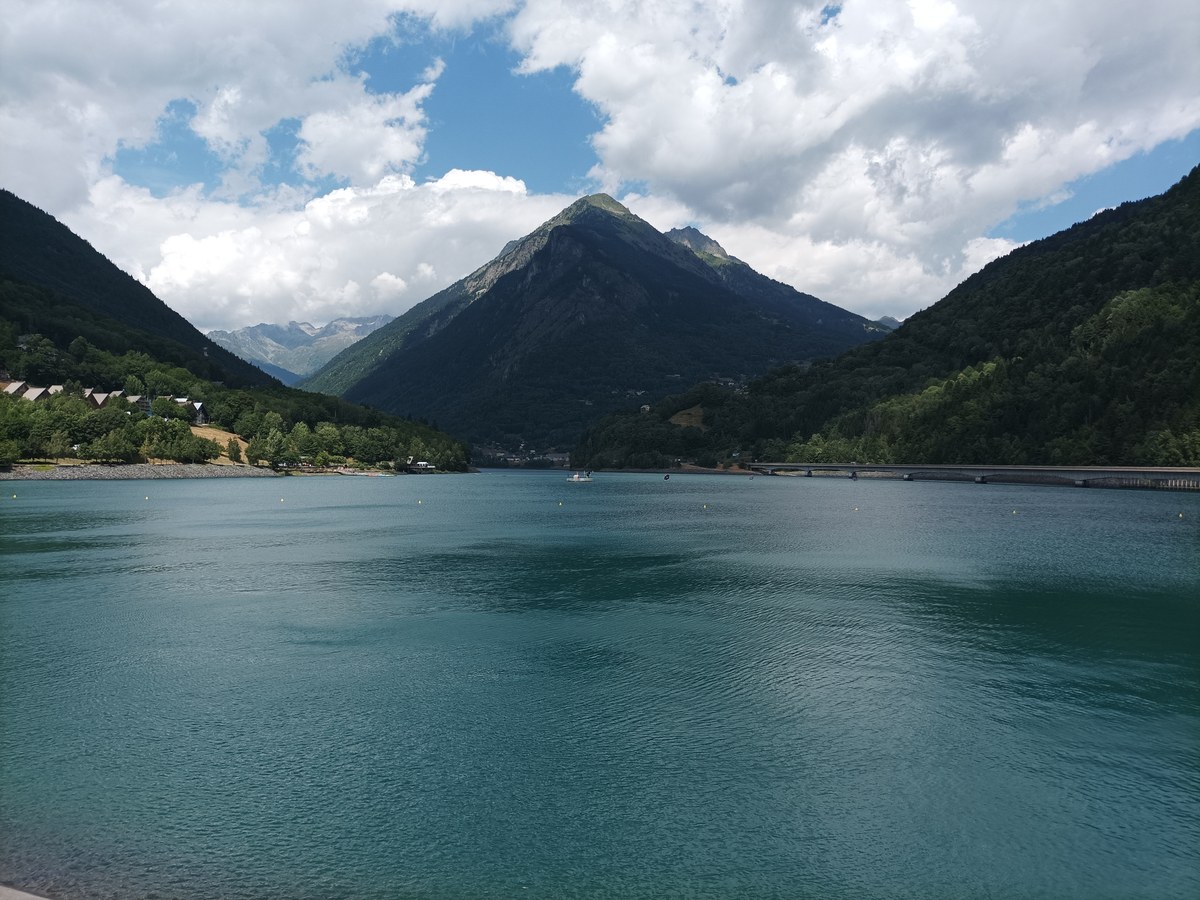 Le lac du Verney vu depuis son barrage, entouré de montagnes boisées
