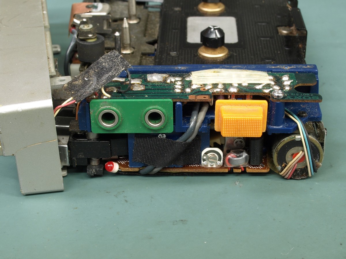 Intérieur d’un Walkman TPS-L2 démonté montrant les deux prises casque vertes et la touche orange